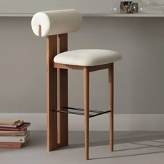 a chair with a white cushion on it next to some books and a book shelf