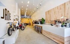 the inside of a store with motorcycles parked in front of it and wooden shelves on the wall