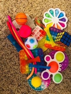 a pile of assorted toys on the floor next to some scissors and pencils