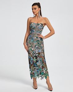 a woman wearing a strapless dress with floral print on the skirt and side slit