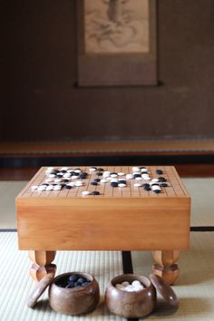 a wooden table with two pairs of shoes sitting on it's legs in front of a painting