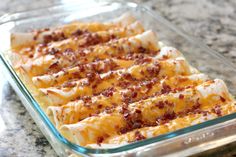 a casserole dish with cheese and bacon in it sitting on a counter top