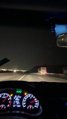 the dashboard of a car at night time with lights on and an airplane in the background