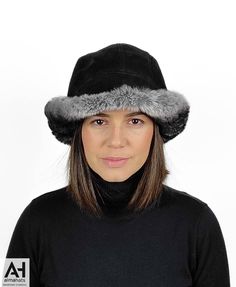 A very fashionable and elegant cloche style hat for women made with very soft rex orylag & black suede sheepskin. Easy to wear and nicely combined materials bring a completeness and an harmory. A hat that can keep you warm and stylish at the same time. Practical and fashionable , this particular hat can be worn in any possible way due to its large brim. This cloche style sheepskin hat is made with 2-sided sheepskin (shearling sheepskin or double face sheepskin). The exterior side has durable bla Winter Black Sheepskin Hats, Black Hat With Faux Fur Lining, Elegant Black Bucket Hat, Winter Fur Felt Hats For Cold Weather, Fur Felt Brimmed Cloche Hat, Faux Fur Lined Brimmed Bucket Hat, Classic Winter Bucket Hat With Short Brim, Luxury Brimmed Cloche Hat, Luxury Winter Hats With Short Brim