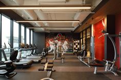 an exercise room with rows of treadmills and machines in front of large windows