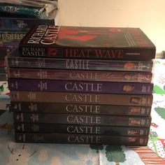 a stack of books sitting on top of a bed next to a christmas themed wallpaper