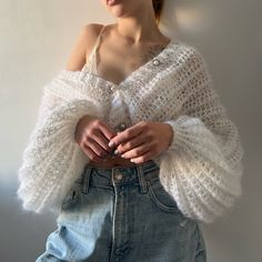 a woman wearing a white crop top and denim skirt with her hands on her hips