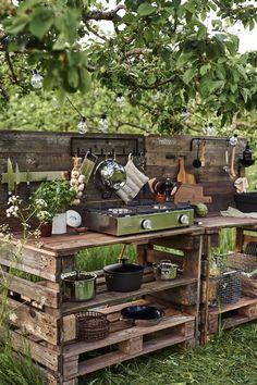 an outdoor kitchen made out of wooden pallets with pots and pans on it