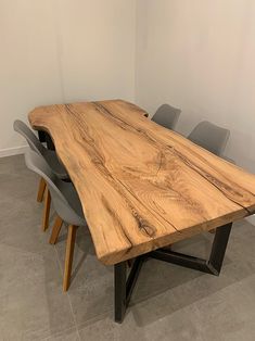 a wooden table with chairs around it in an office setting on the floor next to a white wall