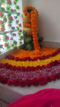 there is a large flower arrangement on the floor in front of a window with flowers all over it