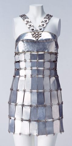 Mini Dress, Paco Rabanne: ca. 1967, aluminum plates and brass wire. "This mini dress made of aluminum plates sums up work of Paco Rabanne, known as the "Metal Worker." The inorganic metal "fabric" makes a striking contrast against the skin. It is one of the monumental dresses of the 1960s, implicating of androids' glowing hard skin in science fiction..." Space Age Fashion, 1960 Fashion, Mary Quant, Fashion 1960s, Sixties Fashion, Costume Institute, Vintage Couture, Warrior Princess, 1960s Fashion