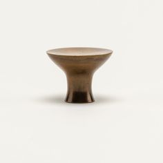 a small brown vase sitting on top of a white table