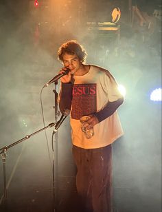 a man standing in front of a microphone on stage