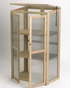 a wooden display case with glass doors and shelves on the front, in an upright position