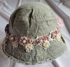 a green hat with pink and white flowers on it