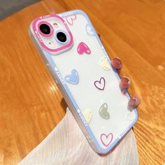 a person holding a phone case with hearts on it and the back cover is clear