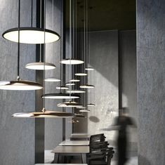 several tables and chairs are lined up against the wall with lights hanging from them in an empty room