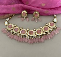 This beautiful pink kundan necklace set with earrings to match has great artistry and will add charm to your attire. It is embedded with kundan and pink stones. The dangling pink beads add a classic sparkle.  Details: Necklace Width-2 Inches Earrings Length-2 Inches Weight of Each Earring-14 gms All products are manufactured using traditional skills from our rich heritage of crafts.  The process of these crafts is essentially manual. Hence, any irregularities or variations are an inherent part of these handcrafting processes. Pink Chandbali Kundan Necklace For Festivals, Pink Bollywood Kundan Necklace, Pink Chandbali Kundan Necklace For Wedding, Pink Chandbali Kundan Necklace With Stone Work, Pink Bollywood Style Kundan Necklace, Pink Gota Work Jewelry For Wedding, Heavy Pink Bridal Necklace For Diwali, Pink Kundan Necklace For Gift, Pink Kundan Necklace As A Gift