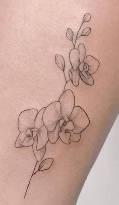 a tattoo on the leg of a woman's thigh with an orchid flower in it