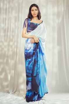 Blue saree with all over Marble bloom print and cutdana embellishments on the scallop border. Paired with a matching printed blouse with crystal tassel embellishments on the cap sleeves. - Aza Fashions Blue Cotton Silk Blouse Piece With Sheer Dupatta, Blue Blouse With Sheer Dupatta, Fitted Reception Blouse With Printed Motifs, Fitted Blouse With Printed Motifs For Reception, Blue Silk Blouse With Dupatta, Blue Georgette Saree For Summer, Blue Pre-draped Saree With Printed Motifs, Blue Georgette Blouse Piece For Summer, Blue Cotton Silk Saree With Printed Motifs