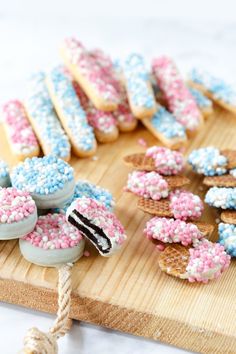 an assortment of decorated cookies and pastries on a cutting board