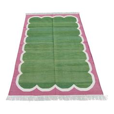 a green and pink rug with fringes on it's edges, in the shape of a christmas tree