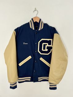 "this jacket is price, even if your name isn't Devin!  it's a classic silhouette in a timeless colorway.  It has a removable liner, hip pockets and is in min condition.  Made in the USA! WHAT: Varsity ERA: 2000s COLOR: Blue/Tan MATERIAL: Wool/Leather/Polyester ORIGIN: U.S.A. CONDITION/WEAR: Mint SHOULDER: 18\" PIT: 19\" SLEEVE: 22\" LENGTH: 26\" ORIGINAL SIZE: XS MODERN SIZE ESTIMATE: XS MEASUREMENTS: Measurements are taken in inches with garment laying flat. The easiest way to ensure a great fit is to measure and compare a similar garment. All of our items are vintage pieces -- They may show natural signs of wear & age. Everything in our store is laundered/or dry cleaned and ready to wear." Lettermans Jacket, Barn Coat, Hunting Vest, Varsity Letterman Jackets, Vintage Woolrich, Realtree Camo, Letterman Jacket, Shearling Jacket, Your Name