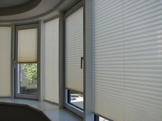 an empty room with white blinds on the windows