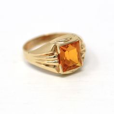 Pretty vintage circa 1940s era 10k yellow gold simulated citrine ring! This beautiful ring features a rectangular faceted yellowish orange glass stone, that is securely bezel set. There are classic linear designs down the shoulders, and the shank is free of design. A lovely piece of fine 1940s era jewelry, featuring November's birthstone color! *Sale - price reduced from $295 USD to $285 USD.  ERA - Circa 1940s - Retro  METAL / MATERIAL - 10k yellow gold, glass  MARKINGS / HISTORY - Inside of band is marked "10K" and with what appears to be "FAITH" CONDITION - Good vintage condition. Yellow gold metal has been professionally polished & cleaned. Glass stone is securely bezel set. Amazing vintage simulated citrine ring!  SIZE / MEASUREMENTS - Size: 5, Ring Head Height: 11.24 mm, Rise Of Ring November Sale, November Birthstone Jewelry, Birthstone Colors, Logo Gifts, Citrine Ring, November Birthstone, Gold Glass, Faceted Glass, Beautiful Ring