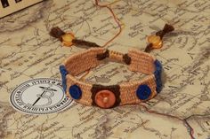 a close up of a bracelet on top of a map with an orange and blue button