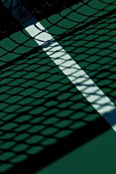 the shadow of a tennis player on the court