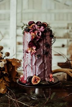 a decorated cake sitting on top of a table next to flowers and antelope