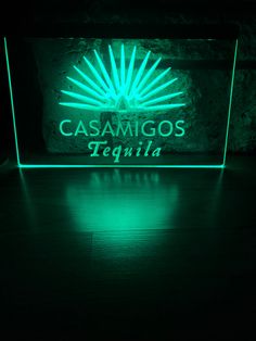 a green illuminated sign that reads casamigoss tequila