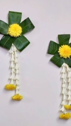 two pieces of paper with flowers and leaves attached to the sides, one is yellow