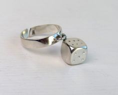 Beautiful vintage sterling silver ring with dangle Dice. Two of the faces of the die are free, without points. Marked: 925 in box Measures: the current 🇺🇸 US size approx 7, adjustable ring, Dice 9x9x9mm Very good vintage condition More Scandinavian sterling silver rings here: https://www.etsy.com/shop/AnteBellumTreasure?ref=seller-platform-mcnav&section_id=38939926 Thank you for your interest! Dangle Ring, Scandinavian Jewelry, 7 Ring, Vintage Sterling Silver Rings, Charm Rings, Adjustable Ring, Adjustable Rings, Rings Statement, Vintage Sterling Silver