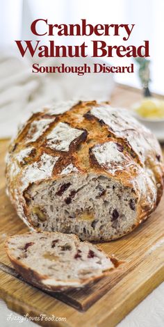 a loaf of cranberry walnut bread sitting on top of a wooden cutting board