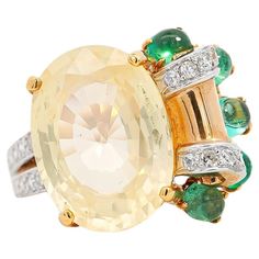 GRS certified no heat 12.61-carat oval cut Ceylon yellow sapphire with 1 carat total in cabochon cut emeralds and 0.30 carats in round cut diamonds. All set in a vintage 18k gold flower motif setting.  The sapphire center stone is known in the trade as a soft yellow sapphire, bearing a more whitish color hue and phenomenal transparency. The cabochon cut emerald side stones blossom on the side of the ring to offer excellent color contrast and texture. Sits beautifully on the finger and commands a Face Measurements, Floral Ring, Soft Yellow, Flower Motif, No Heat, Gold Flower, Color Contrast, Yellow Sapphire, Gold Flowers