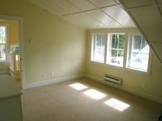 an empty room with three windows and no one in it