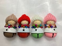 three little dolls sitting on top of each other wearing hats and holding ornaments in their hands