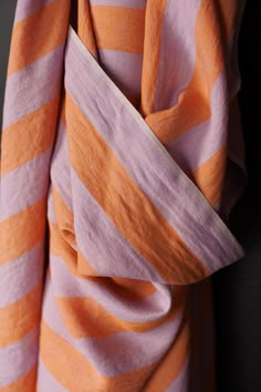 an orange and pink striped scarf hanging on a wall