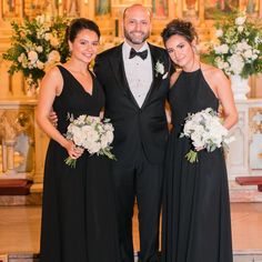 two women and a man in formal wear standing next to each other at a wedding