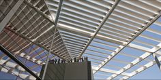 the inside of a building with metal roofing and glass walls on it's sides