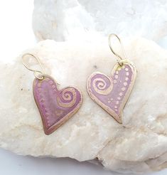 Hand drawn, salt water etched using no chemicals, brass heart with swirls and dots, hand painted in pink tones and finished with a clear enamel to protect color. With gold vermeil ear wires. About 1 1/2" wide by 1 1/2" long and very light weight. Artistic Heart Earrings As Gift, Artisan Heart Earrings For Pierced Ears As Gift, Artisan Heart Earrings As Gift, Artistic Etched Earrings As A Gift, Artistic Heart-shaped Earrings For Gift, Handmade Artisan Heart Earrings, Nickel-free Unique Heart Earrings, Unique Nickel-free Heart-shaped Earrings, Unique Heart-shaped Earrings