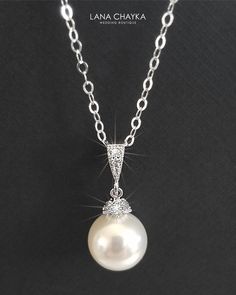 Wedding Swarovski 10mm White Pearl Drop 925 Sterling Silver Chain CZ Bridal Necklace. CHAIN is 18 inches (45.7 cm) long. PENDANT is about 1 inch (2.4 cm) long including bail. MATCHING EARRINGS: https://www.etsy.com/listing/95683858/white-pearl-drop-bridal-earrings?ref=shop_home_active_2 This necklace is made with 925 Sterling Silver chain, Swarovski 10mm White round crystal pearl, Rhodium Sterling Silver pearl component with clear Cubic Zirconia stones, and silver (Original Rhodium) plated bail Classic White Gold Necklace For Wedding, Classic White Gold Bridal Necklace For Wedding, Classic Wedding Necklace With Round Pendant, Classic Pearl White Bridal Necklace For Wedding, Sterling Silver Pearl Chain Jewelry For Wedding, Classic Round Pendant Necklace For Wedding, Classic Bridal Necklace With Pearl Pendant For Wedding, Sterling Silver Wedding Necklace, Classic Pearl Chain Jewelry For Weddings