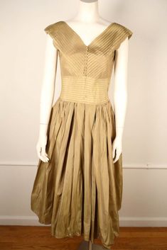 "1950's rayon faille full circle dress with pleated details. Has button details on the front neck with a ballerina length skirt.  Good condition: Several slight brown stains on the skirt- not very noticeable due to volume and gathered nature of the skirt's fabric. Will fit size S-M: L: 48.5\" , C: 35 \" , W: 28\" , free hip" Vintage A-line Dress With Pleated Waist, Vintage A-line Dress With Pleated Bodice, Vintage A-line Pleated Dress, Vintage Party Dresses With Pleated Waist, Pleated Vintage Dress For Party, Vintage Dresses With Pleated Bodice And Tea Length, Vintage Pleated Dress For Party, Vintage Pleated Dresses With Fitted Bodice, Vintage Tea Length Dress With Pleated Bodice