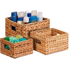 three wicker baskets filled with bottles of lotion and soaps on white background