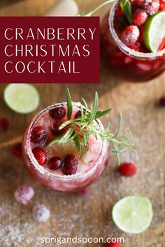 two cranberry christmas cocktails with lime and rosemary garnish on the rim