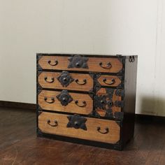 an old wooden dresser with metal knobs on it's drawers and wood flooring