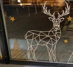 a glass window with a deer drawn on it's side and gold stars in the background