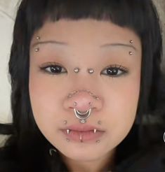 a woman with piercings on her nose and nose ring in front of her face